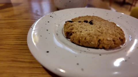 Warmly lit scene featuring textured cookie on wooden surface Stock Footage 322685935