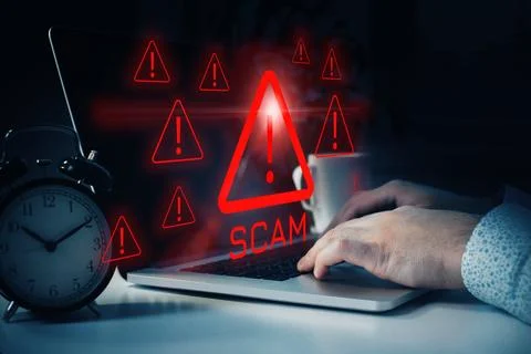 Warning about a scam message displayed on a laptop with alerts at night 写真素材