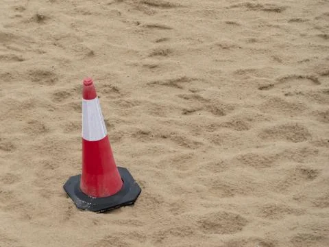 Warning cone on the sand of a beach Stock Photos