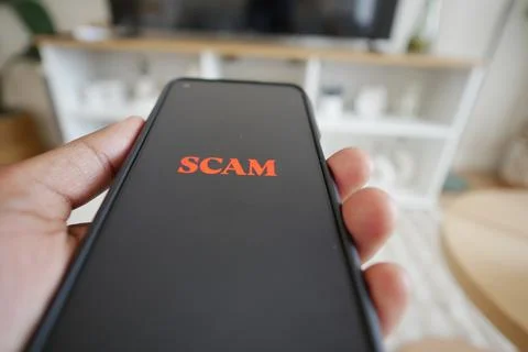 Warning displayed on smartphone screen about scam Stock Photos