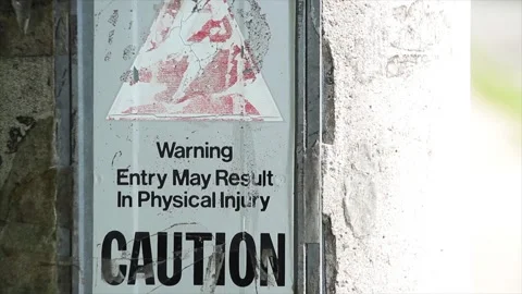 Warning entry may result in physical injury caution sign on cement concrete post Stock Footage 251355083