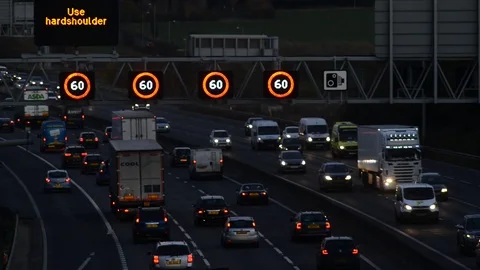 Warning gantry lights of speed restriction in traffic jam on the M62 motorway uk Stock Footage 83159373