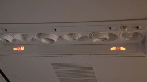 Warning Lights Indicating Need to Fasten Seat belts in Passenger Airplane During Stock Footage 303372888