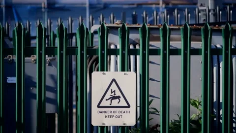 Warning sign of danger of death keep out at electricity substation uk Stock Footage 144372745