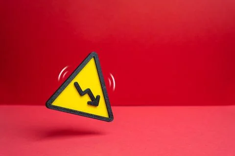 Warning sign with a downward arrow. Declining revenue. Losses and reduction.. Stock Photos