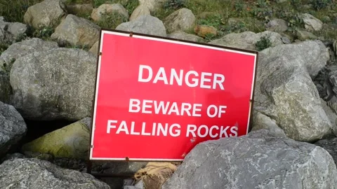 Warning sign of falling rocks below cliff at staithes uk Video stock 138809105