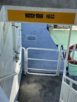Warning sign on a ferry deck with vibrant colors and structural elements Stock Photos
