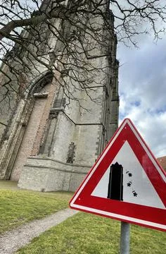 Warning sign of flowers falling down a church Stock Photos