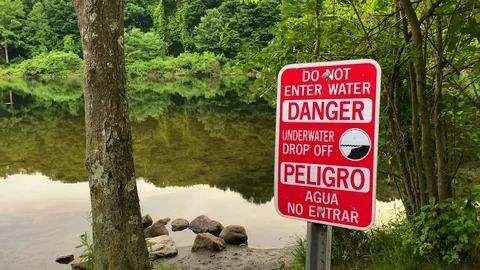 Warning Sign in Forest Lake warns visitors it is Dangerous to enter the water Stock Footage 123431702