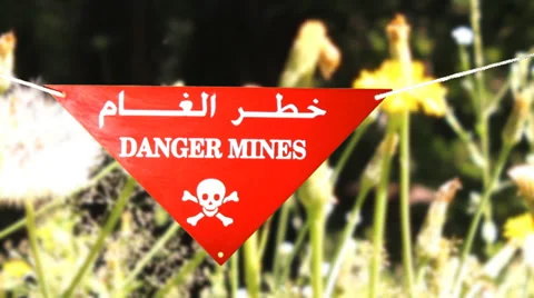 Warning sign in front of a minefield Stock Footage 37926252