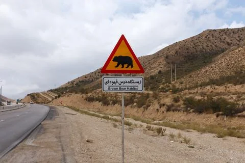 Warning sign indicates brown bear habitat along Gorgan Bojnord road in Iran Stock Photos