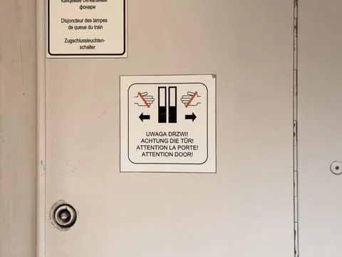 Warning sign with multiple languages indicating door attention and hand cau.. Stock Photos