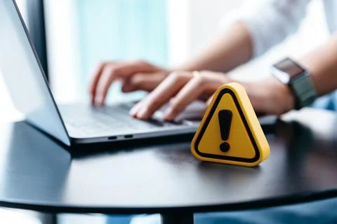 Warning sign placed on a table while businesswoman work. Stock Photos