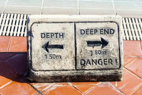 Warning sign by the pool. labeled "Depth" and "Deep End" Stock Photos