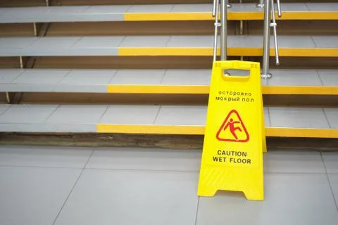 Warning sign with Russian text caution wet floor. A sign near the steps in an Stock Photos