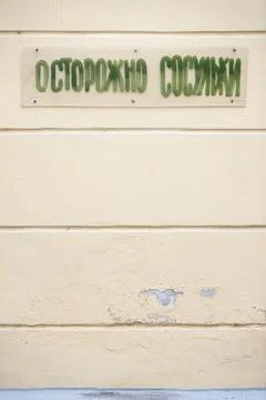Warning sign in Russian, on the wall of the house - Beware of icicles. Stock Photos