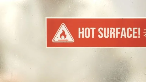 Warning sign shows hot surface in a busy area Stock Footage 328692248