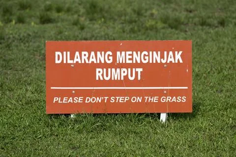 Warning sign with text Please Don't Step on the Grass in a public park Stock Photos