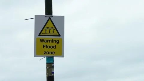 Warning sign with text Warning Flood zone mounted on pole against cloudy sky. 스톡 동영상 331159729
