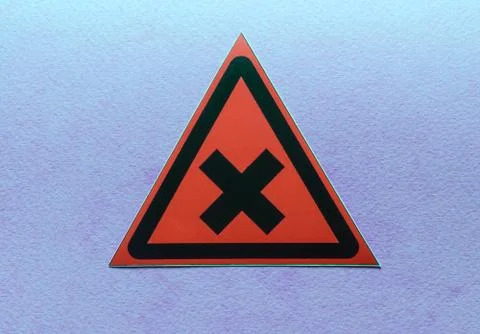 Warning sign two intersecting lines in a red triangle on a blue background Stock Photos