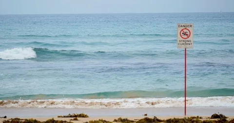 Warning of strong current by rocky open waves Stock Footage 129305212