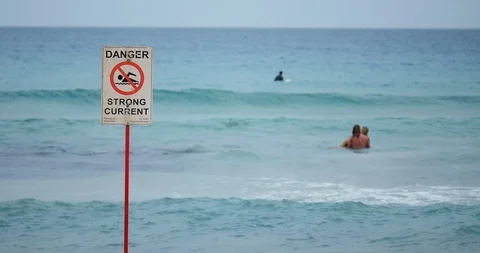 Warning of strong current by rocky open waves Stock Footage 129307817