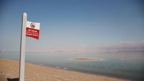 Warning, swimming is prohibited, risk of drowning. Sign at hebrew and arabic Stock Footage 183395095