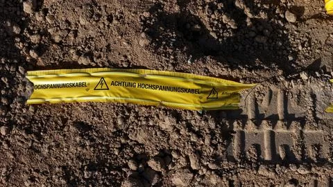 Warning Tape for High-Voltage Cable Marked on Excavation Site – Aerial Close-Up 写真素材
