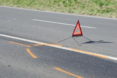 Warning triangle and drift marker on the road after the accident Stock Photos
