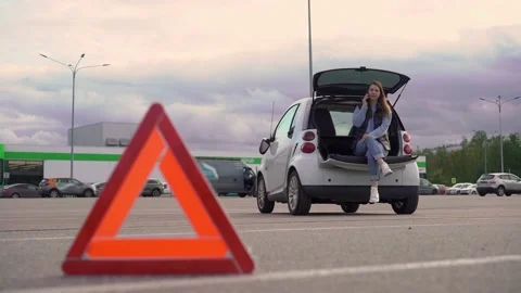 Warning triangle. Car with flashing emergency light in parking accident. Woman. Vídeo Stock 161037564