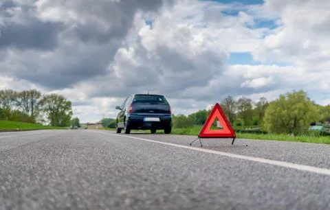 Warning triangle in front of a car with a breakdown Stock Photos