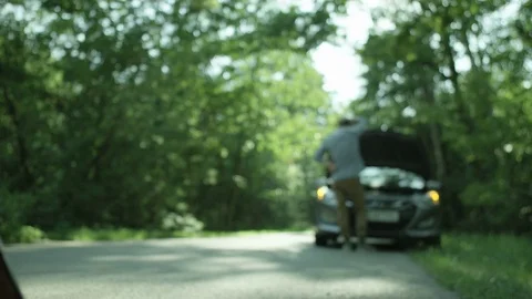 Warning Triangle. Man Looking at the Engine of his Car Stock Footage 79735588
