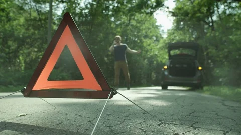 Warning Triangle. Man Walking and Talking on the Phone Stock Footage