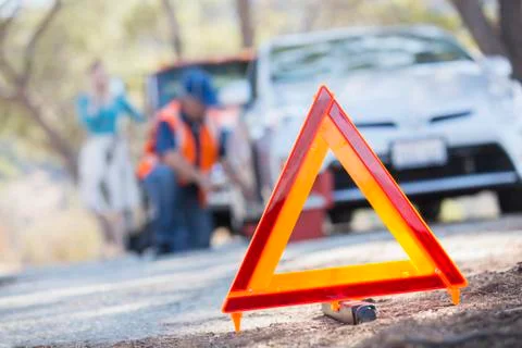 Warning triangle on road with mechanic in background Stock Photos