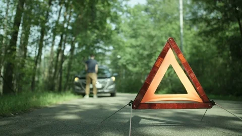 Warning Triangle. Young Man Opening the Hood of a Car Stock Footage 79734611