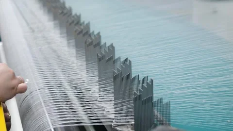 Warping machine close-up, threads are pulled, worker removes thread knot Stock Footage 272588577