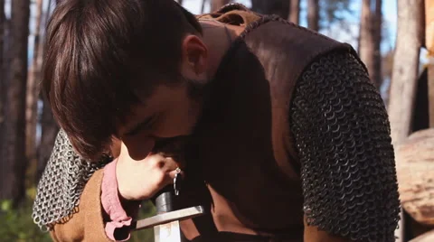 Warrior In Chain Mail Cleans Rubs Sword In Forest Stock Footage 63078052
