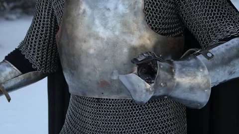Warrior in chain mail hits himself on a steel breastplate with a plate glove Stock Footage 262968994