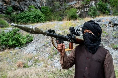 Warrior holds a rocket launcher while standing in a rocky area surrounded b.. Stock Photos