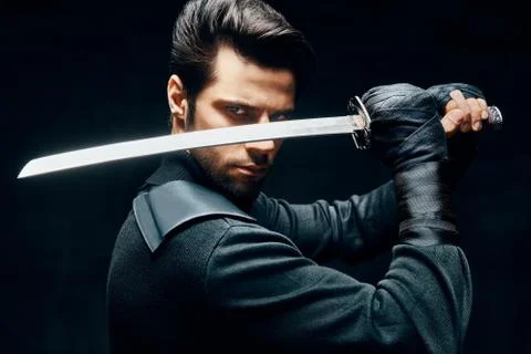 Warrior man posing with a sword ready to stab enemy Stock-Fotos