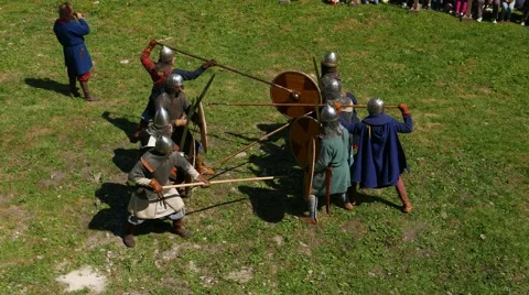 Warriors in two groups fight by spear and defend using round shield Stock Footage 61796226