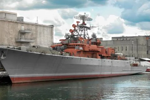 Warship on pier. Dramatic clouds. Close-up Stock Photos