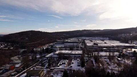 Warsteiner brewery with snow-covered rooftops, surrounded by hills and urban Stock Footage 328731227