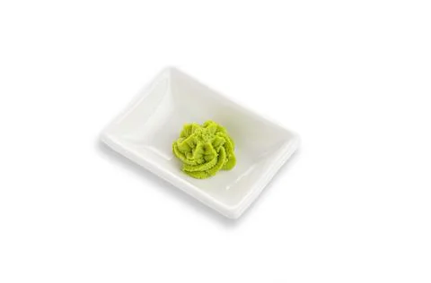 Wasabi in a white rectangular gravy boat. Seasoning for sushi. White backgrou Stock Photos