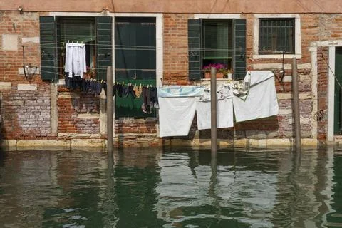 Wäsche hängt zum Trocknen auf der Leine vor den Fenstern einer Wohnung an . Stock Photos