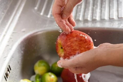 Wash apple to eliminate contamination by viruses and bacteria. Coronavirus Stock Photos