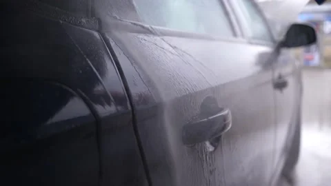 Wash off the foam from the surface of the car - driver person washing his vehicl Stock Footage 170778773