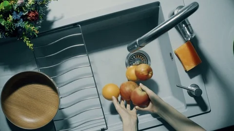 Wash fruit in the sink under running water Video stock 72455276