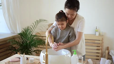 Wash hands routine hygienic procedure Asian mom helps girl Spbd Stock Footage 157823355