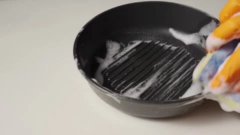Wash the Pan with a Sponge and Detergent. A Gloved Hand with a Sponge Washes the Stock Footage 170551987